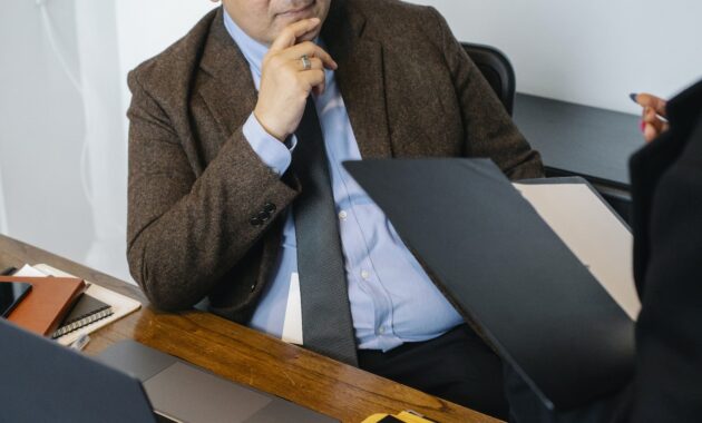 Crop unrecognizable colleagues analyzing documents in office